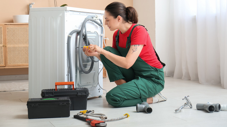 A person repairing a washing machine