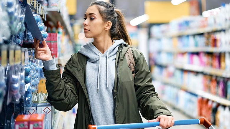 Person shopping in store taking a closer look at a package from a hook