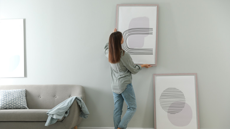 Person hanging up artwork