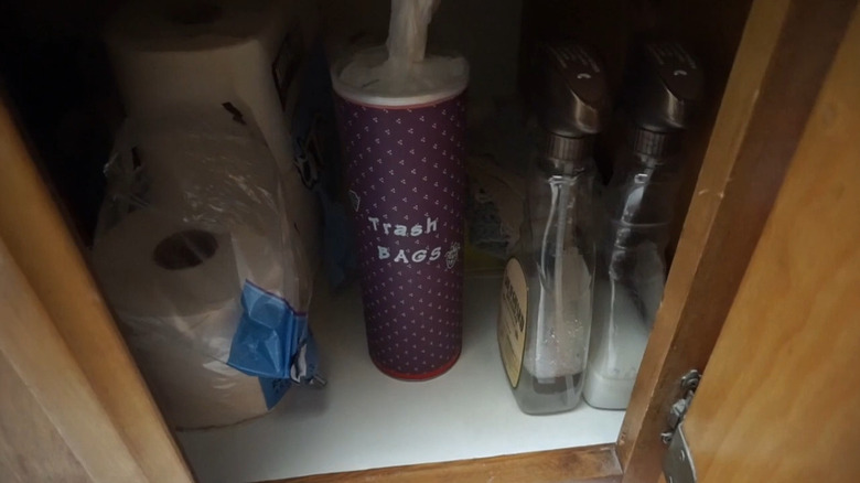 A cylindrical chip filled with plastic bags inside a cabinet.