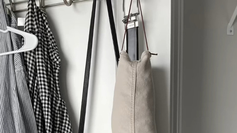A pant leg repurposed into plastic-bag storage hangs from hooks