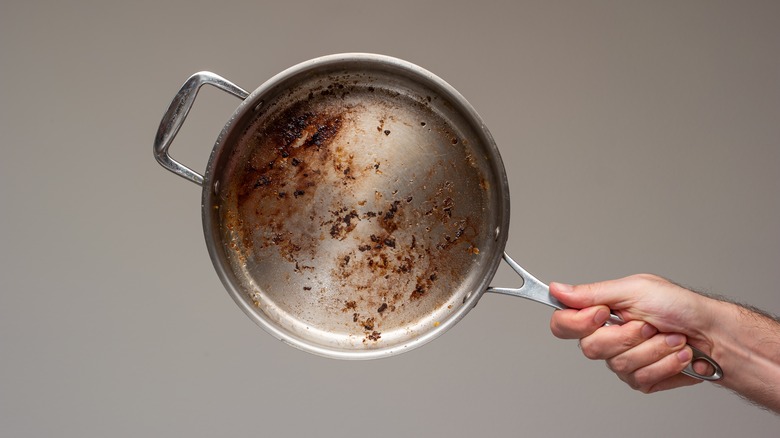 hand holding dirty pan