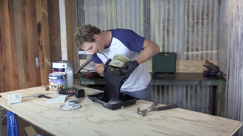 Man pours paint through a stocking