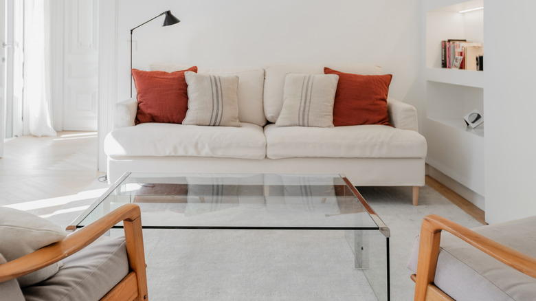 small living room with a rectangle glass coffee table with chrome edging