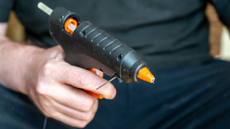 Person holding hot glue gun
