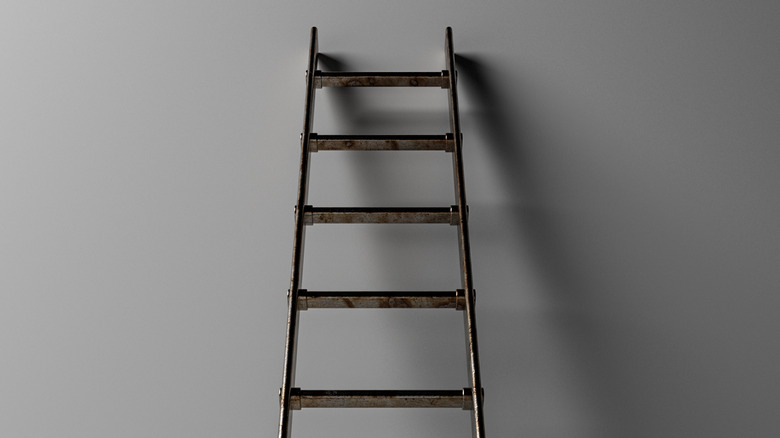 ladder leaned against gray wall