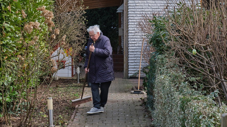 woman sweeping with old broom