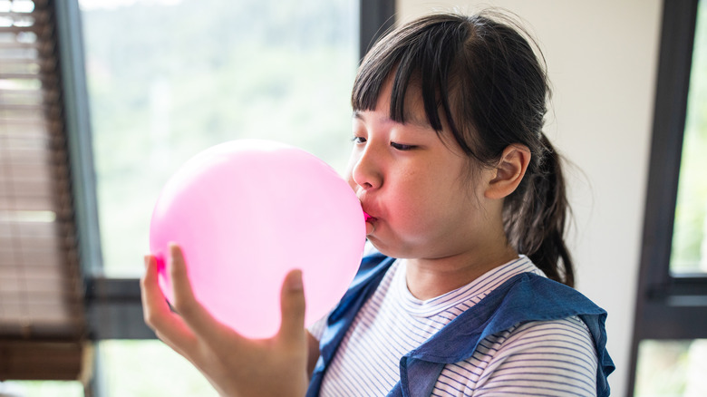 Woman blowing up balloon