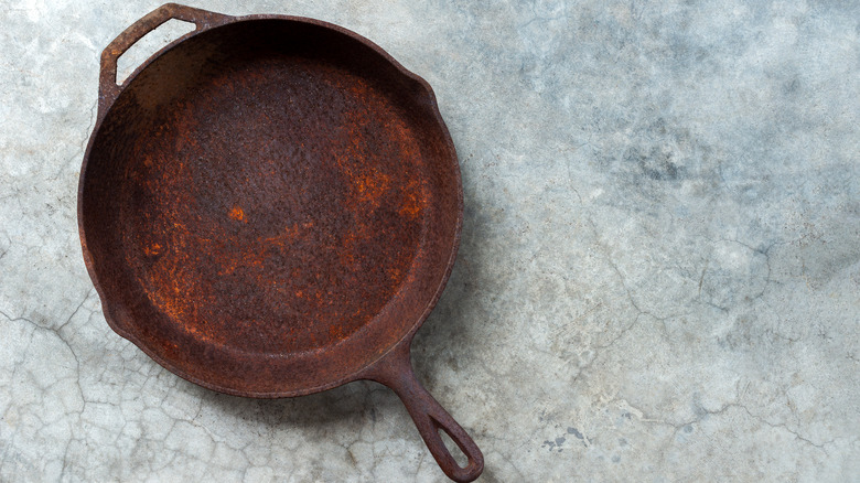 Person cracking eggs into cast-iron pan