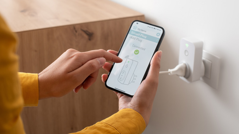 A person setting up a smart plug on a smartphone