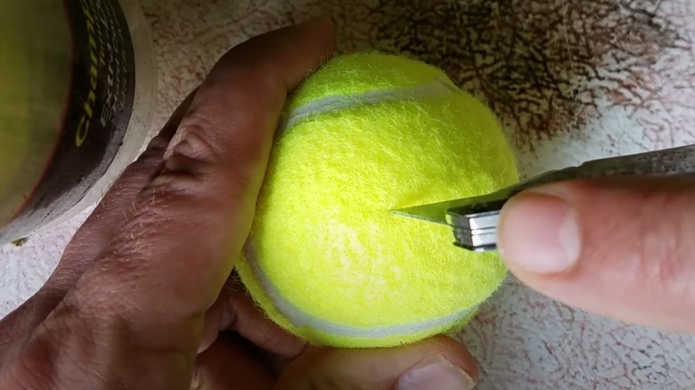 person cutting a tennis ball