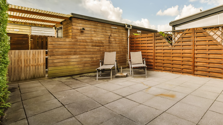 A paved backyard with a patio and no lawn