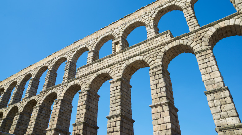 An angled shot of a Roman aqueduct in Spain