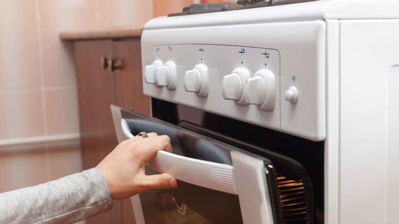 Woman opens oven door