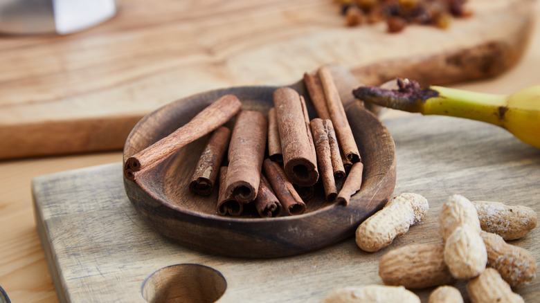 Bowl of powdered cinnamon with cinnamon sticks