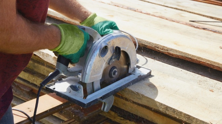 Person cutting rough lumber with circular saw