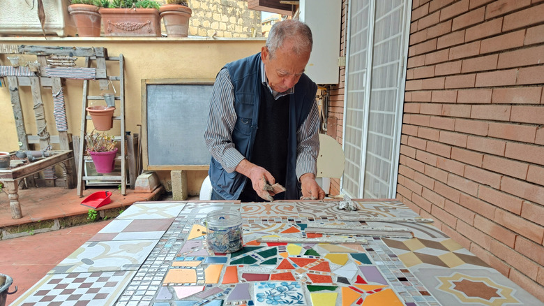 Man creating a mosaic tile table