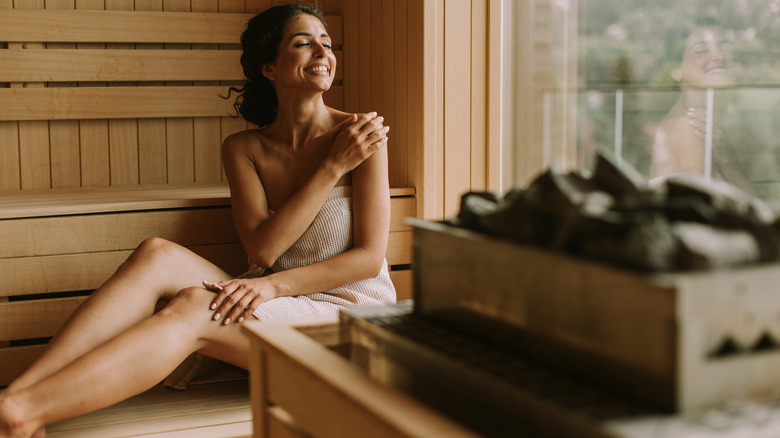 Woman relaxing in outdoor sauna