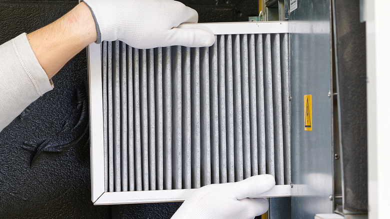 Person inserting a furnace filter