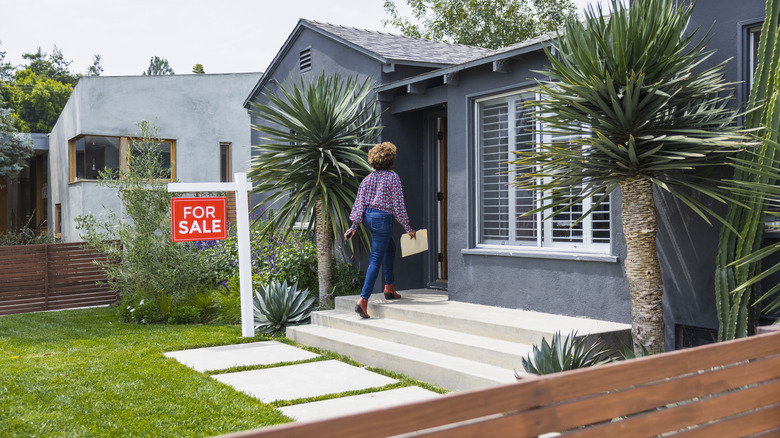 A woman walking into a house for sale