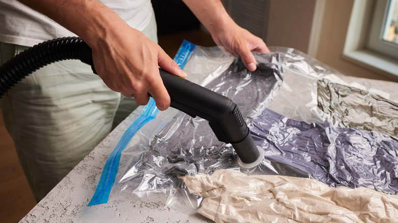 Person vacuuming storage bags