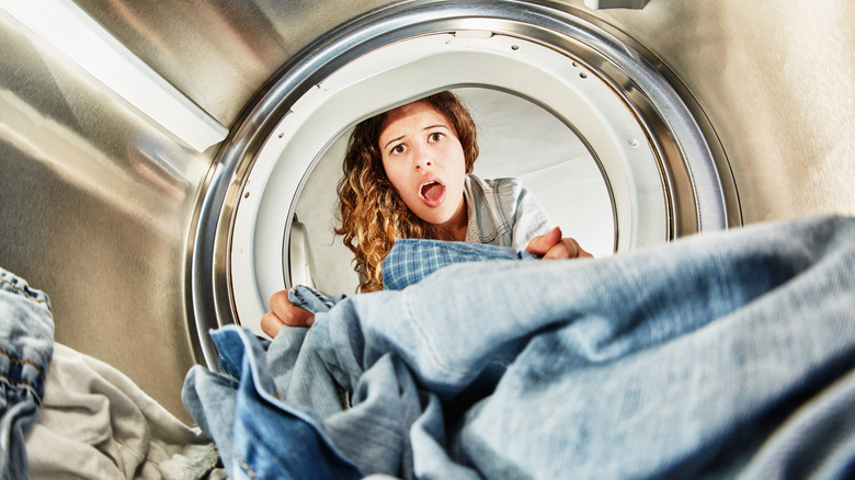 Startled person looking inside a dryer