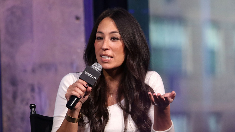 Joanna Gaines holds a microphone as she attends an event.