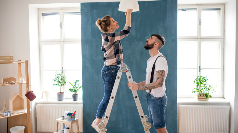man and woman putting in lightbulb