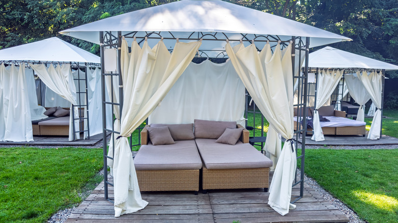 three backyard pergola daybeds with curtains