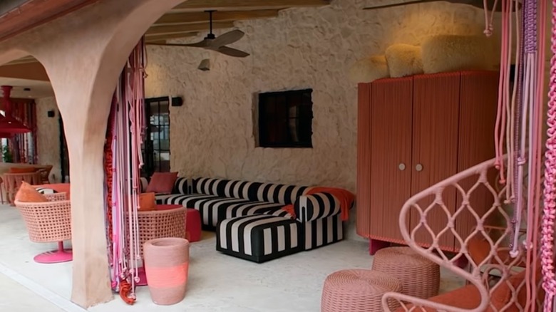 David Bromstad colorful macrame outdoor curtains in a plaster and stone arched entryway