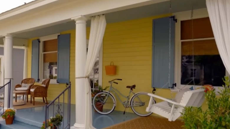 yellow and blue house front porch with curtains on pillars