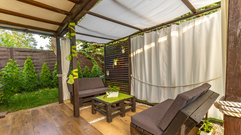 modern fabric awning paired with curtains on backyard pergola