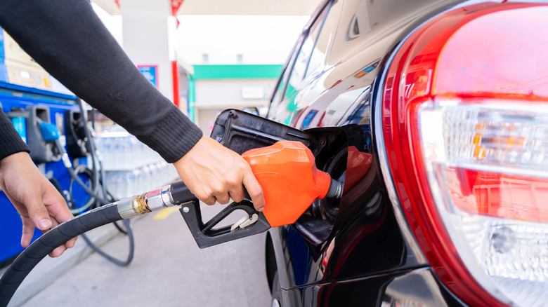 man holding fuel pump to fill gas