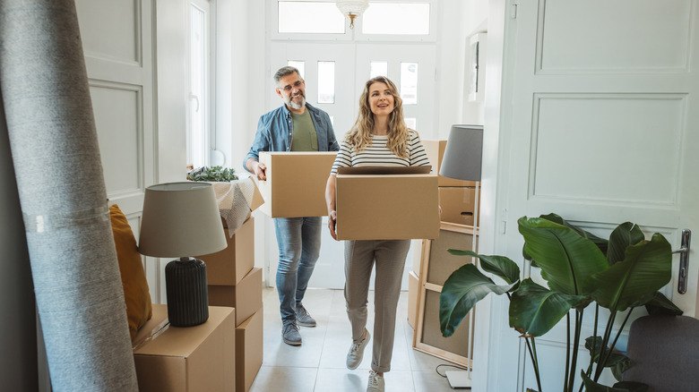 Couple moving boxes into home