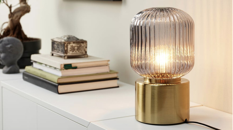 IKEA SOLKLINT table lamp next to stack of books