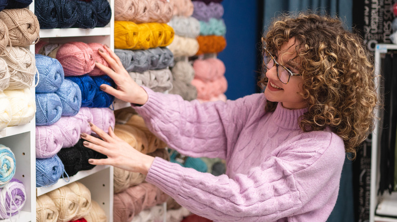 A woman shops for yarn in a craft store