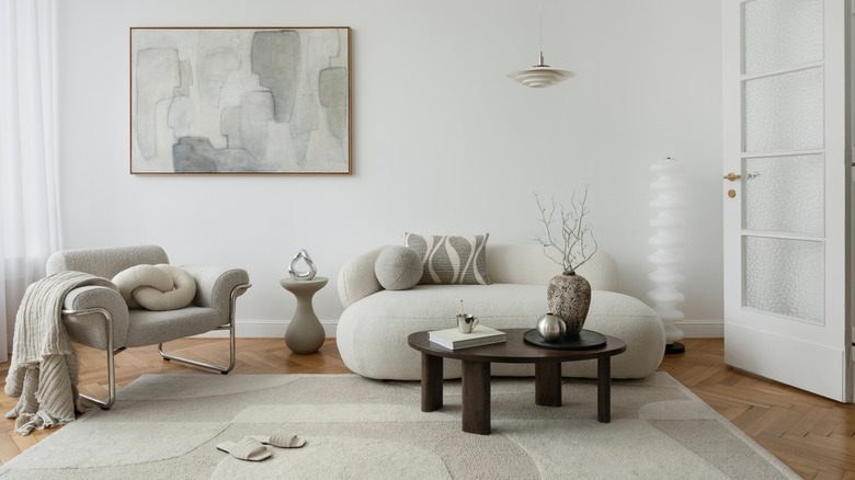 Subtle colors in a patterned rug, painting, and throw pillow