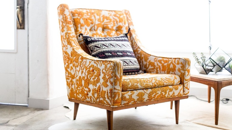 Floral patterned accent chair with a geometric striped pillow