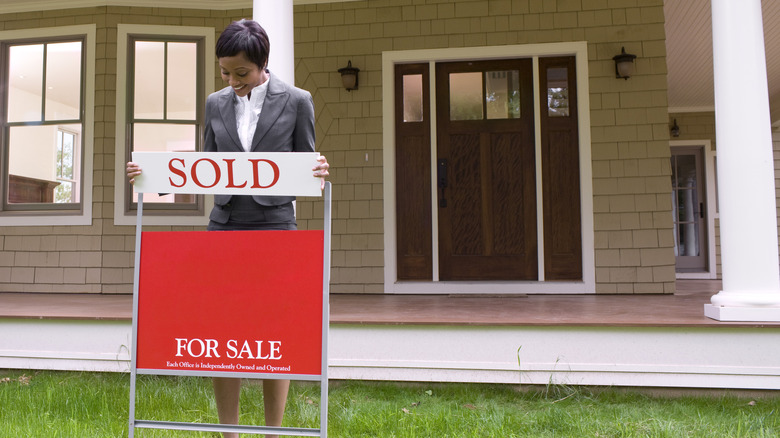 woman holding sold sign