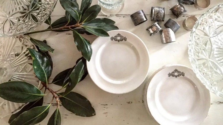 Plates, crystal, leaves on table