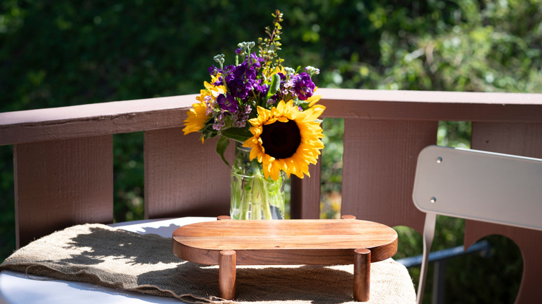 Ball Mason Jar with flowers sitting on an outdoor table in the sunshine