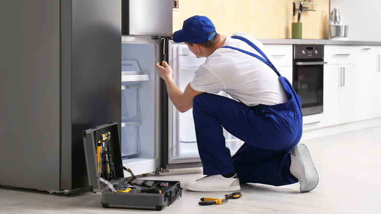 Man fixing refrigerator door