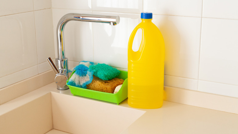 Cleaning products stored on the ledge of a sink