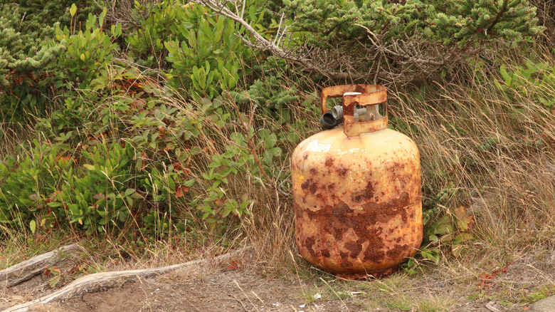A rusty propane tank outside