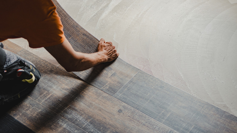 Close-up of a person installing vinyl floors