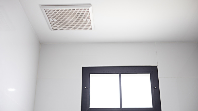 A bathroom ventilation fan on a white ceiling