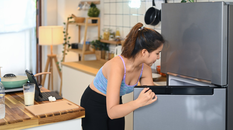 A person reaching into a fridge