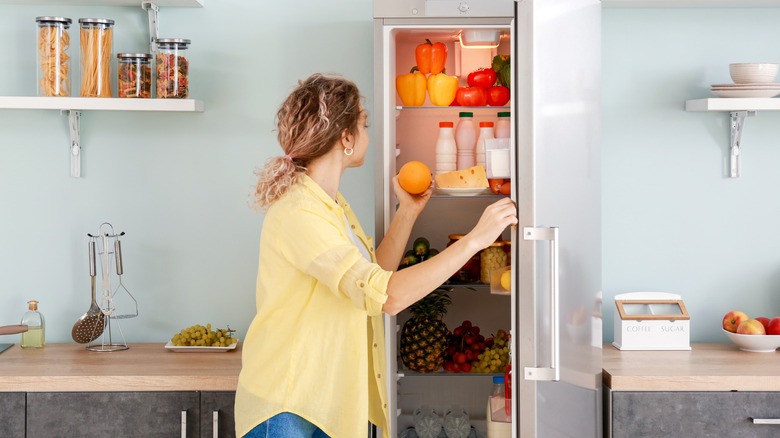 Woman looking inside refrigerator