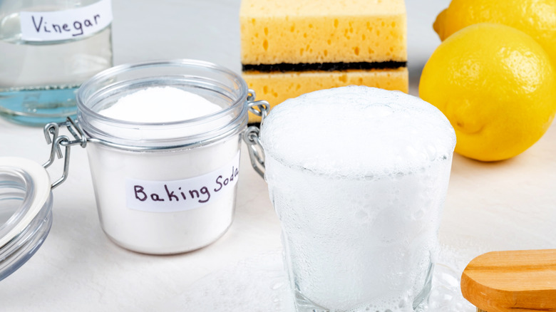 jar of baking soda next to vinegar and lemons