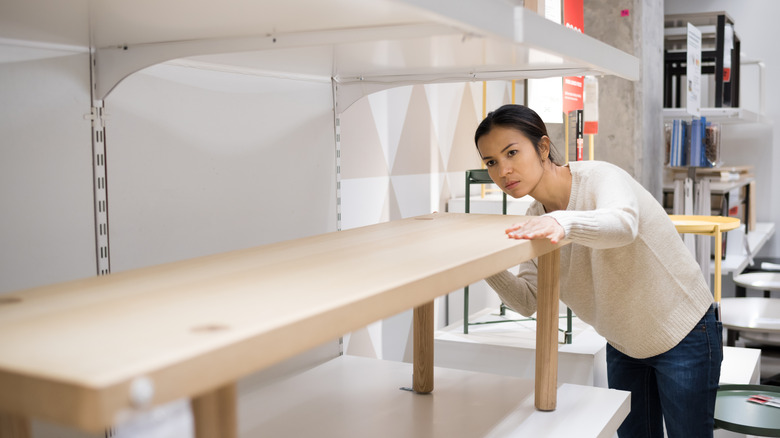 Woman examining a table in IKEA
